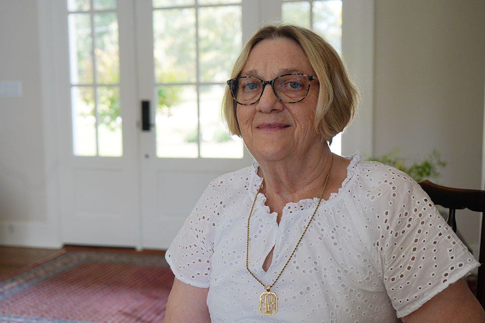 A woman poses for a photo in her home.