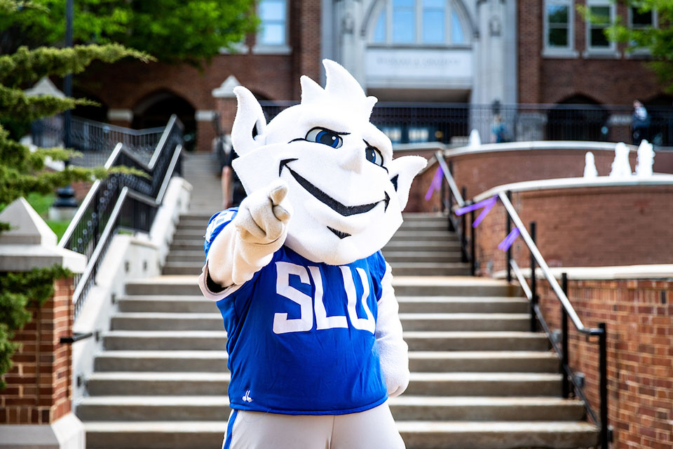 The Billiken poses for a photo outside on campus.