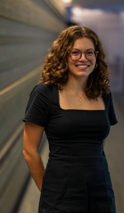 A female student wearing glasses smiles