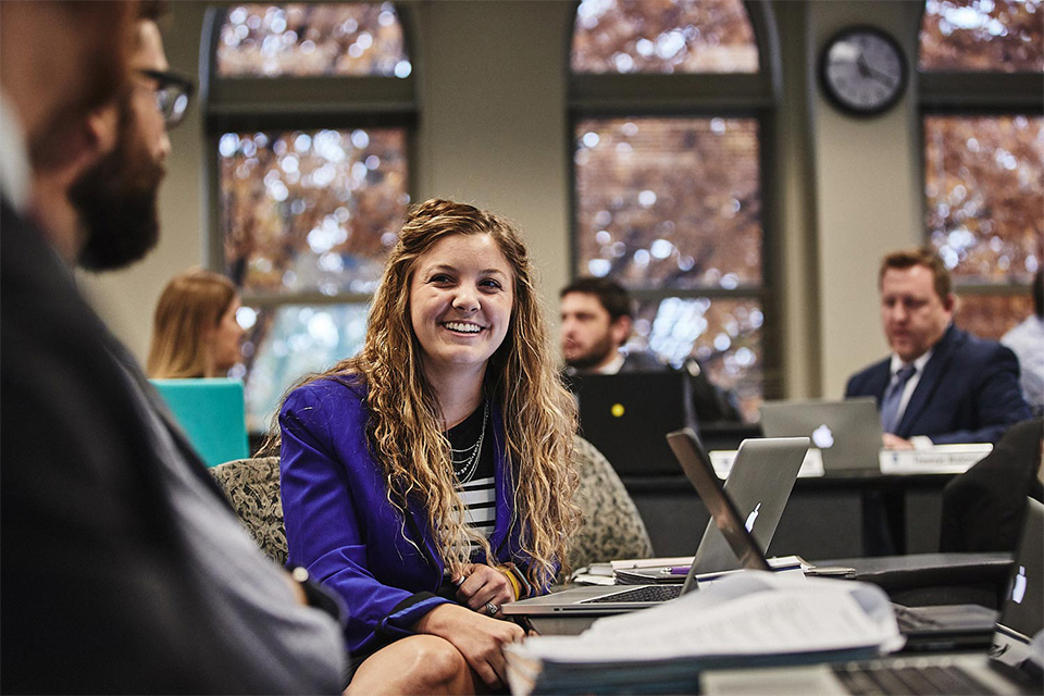 A small group of graduate business students discuss a class project. 