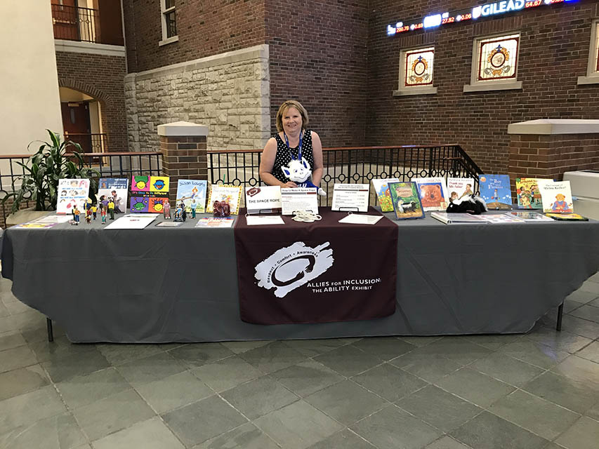 Professor at table with children's books