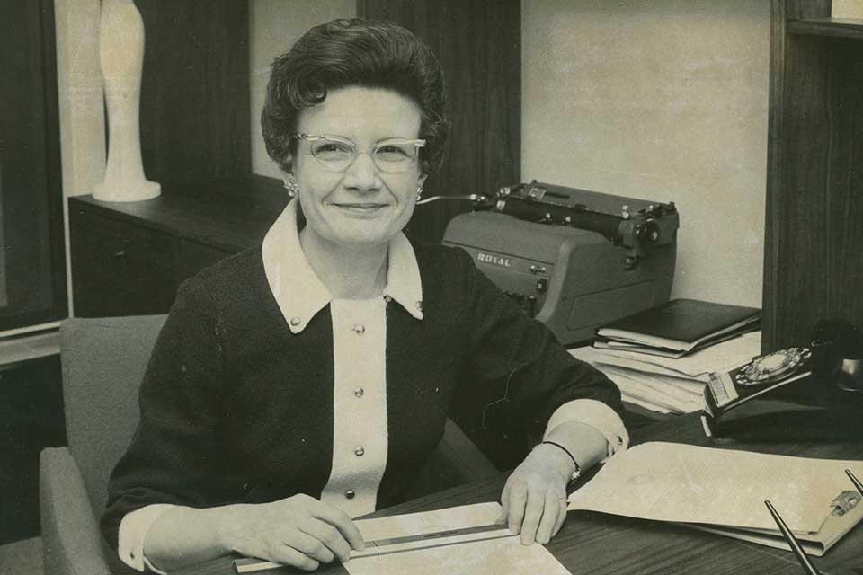 A historic picture of Mary Bruemmer sitting at a desk