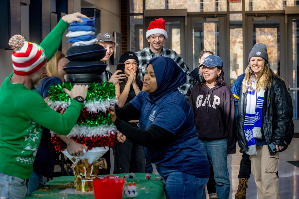 Students watch as a gingerbread house is being crushed.