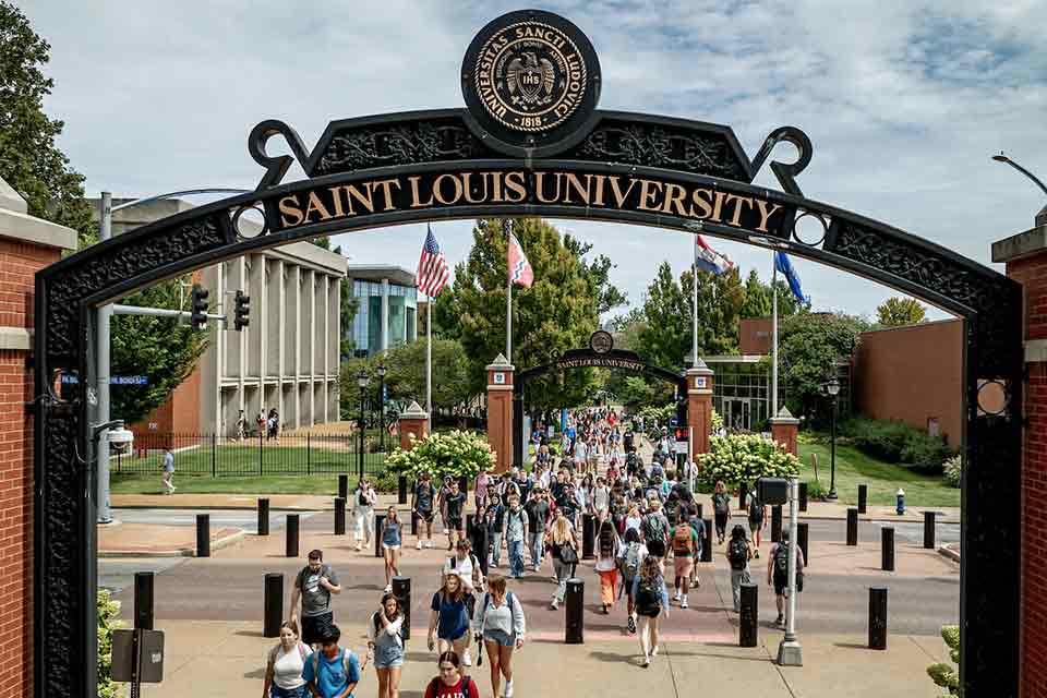 Students cross Grand Boulevard in front of Busch Student Center on a sunny day.