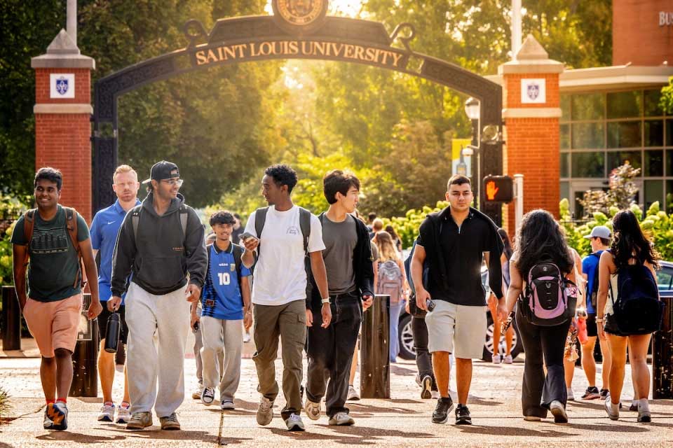 Strategic Plan index Students cross Grand in front of SLU's pedestrian gate.