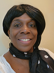 Smiling woman with a polka dotted sash tied around her neck